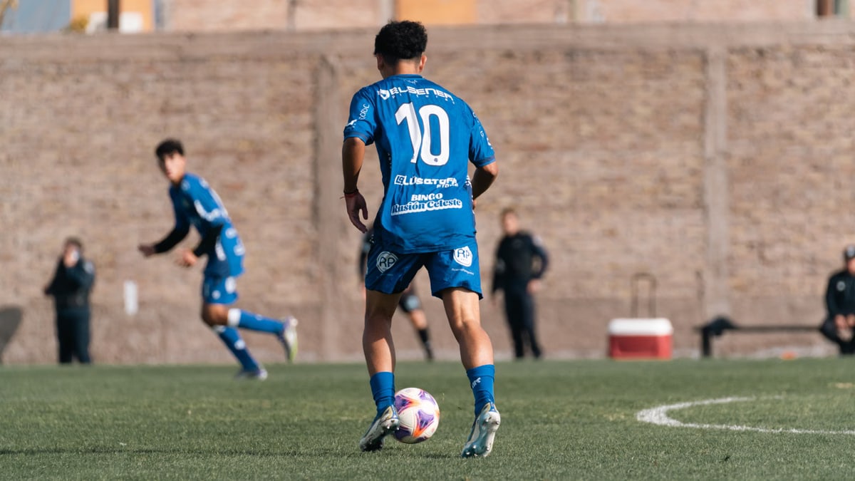 Soccer player wearing number 10 blue jersey during a match on a sunny day.